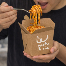 Homme qui mange des pâtes dans un pots en carton kraft personnalisé
